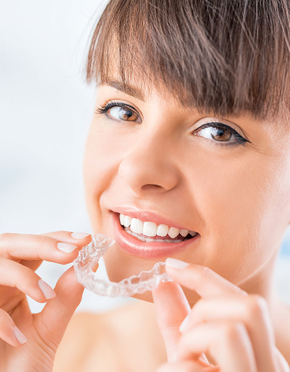 a woman putting in her invisalign clear aligner