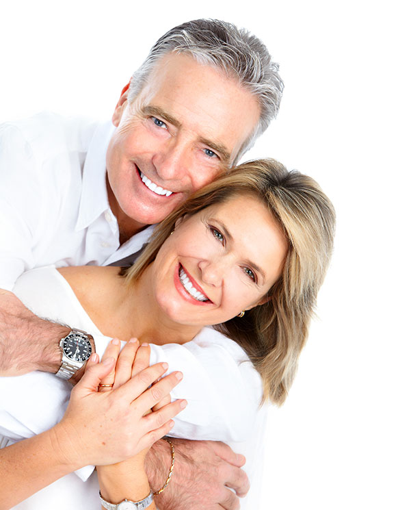 an elderly couple hugging each other while smiling with perfect teeth