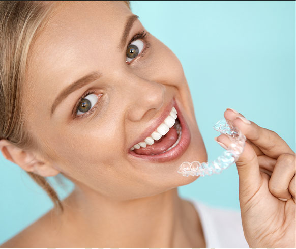 a girl showing perfect teeth and invisalign at smith dentalworks