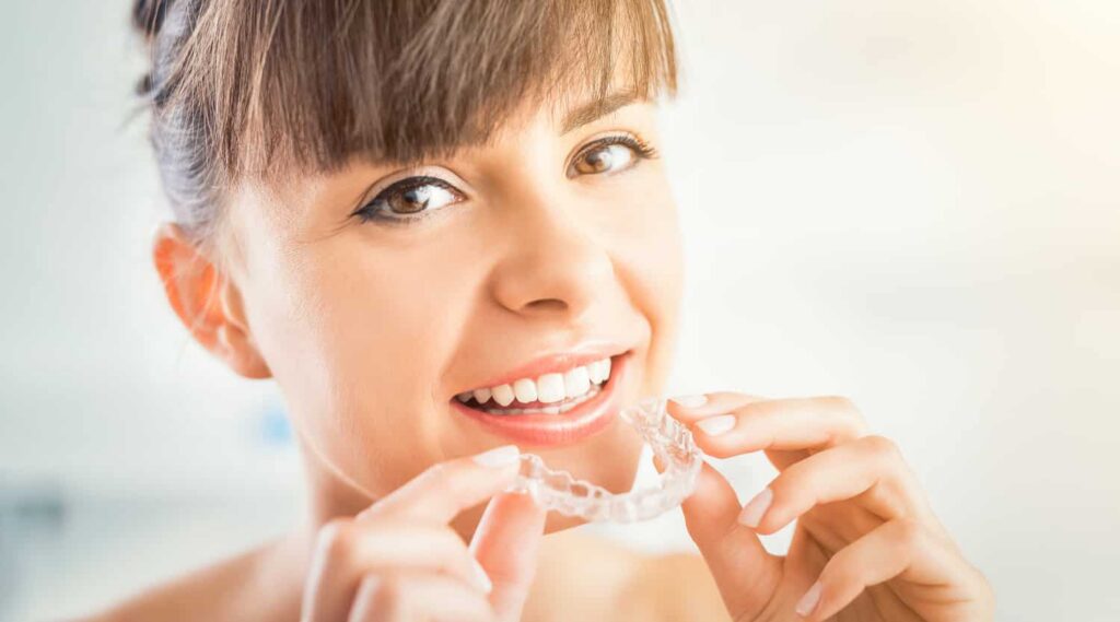 a woman using invisalign to fix her crooked teeth