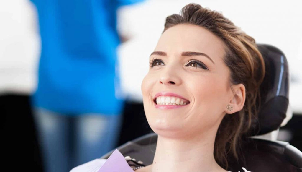 a woman in a black dental chair smiling at smith dentalworks
