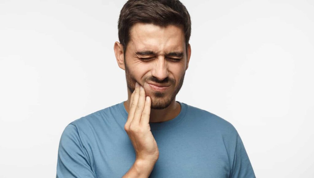 a man with a toothache due to tooth decay and cavities