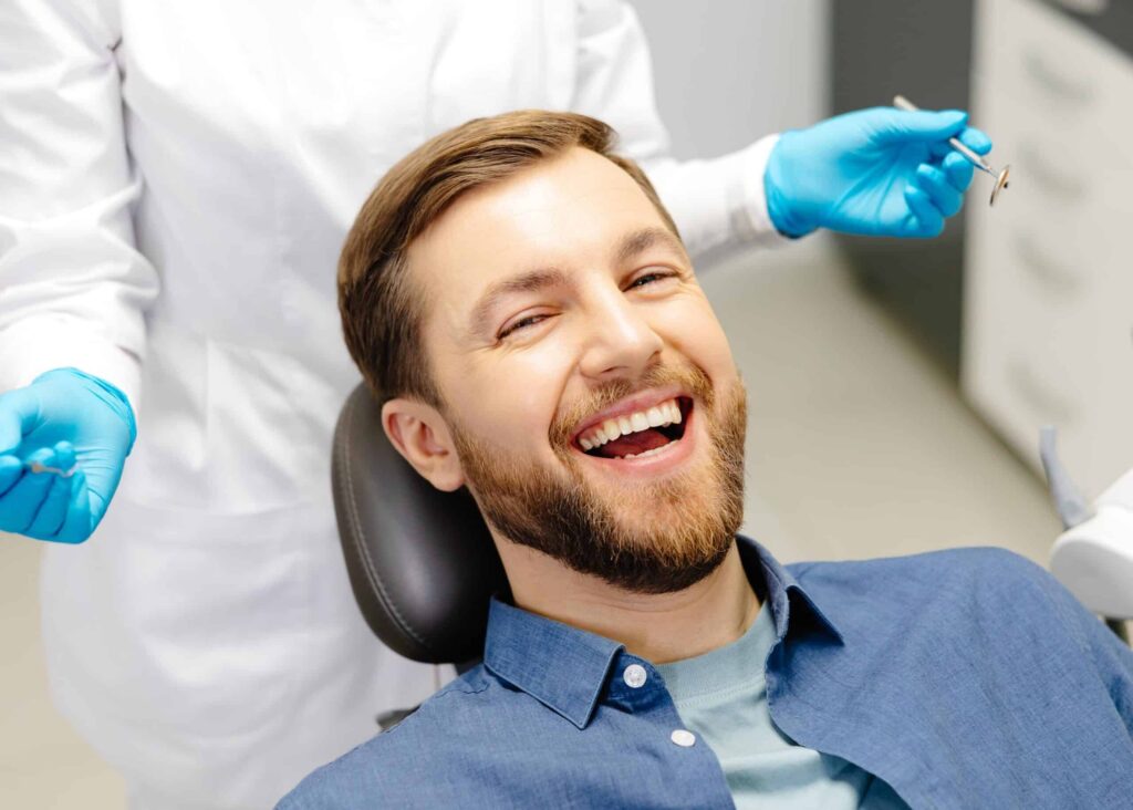 Smiling man in dental chair during check-up, showcasing positive dental health experience at Smith Dentalworks.
