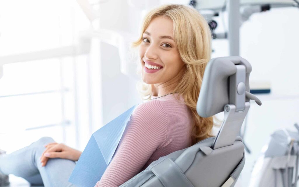 Smiling woman in dental chair, ready for laser dentistry treatment at Smith Dentalworks, emphasizing pain-free care and patient comfort.