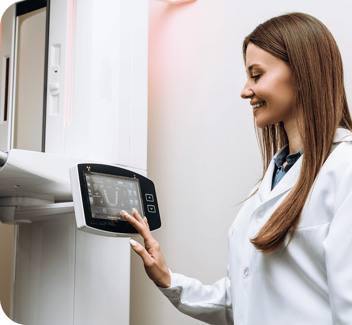 Dental professional operating a CBCT 3D digital imaging machine, emphasizing advanced diagnostics and patient safety in dental care.