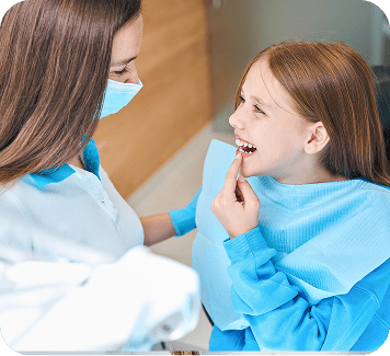 Dentist interacting with a smiling young girl in a dental office, highlighting gentle care for children's dental health at Smith Dentalworks.