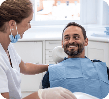 Dentist smiling and comforting patient in dental chair, emphasizing patient care and comfort during tooth extraction procedure at Smith Dentalworks.